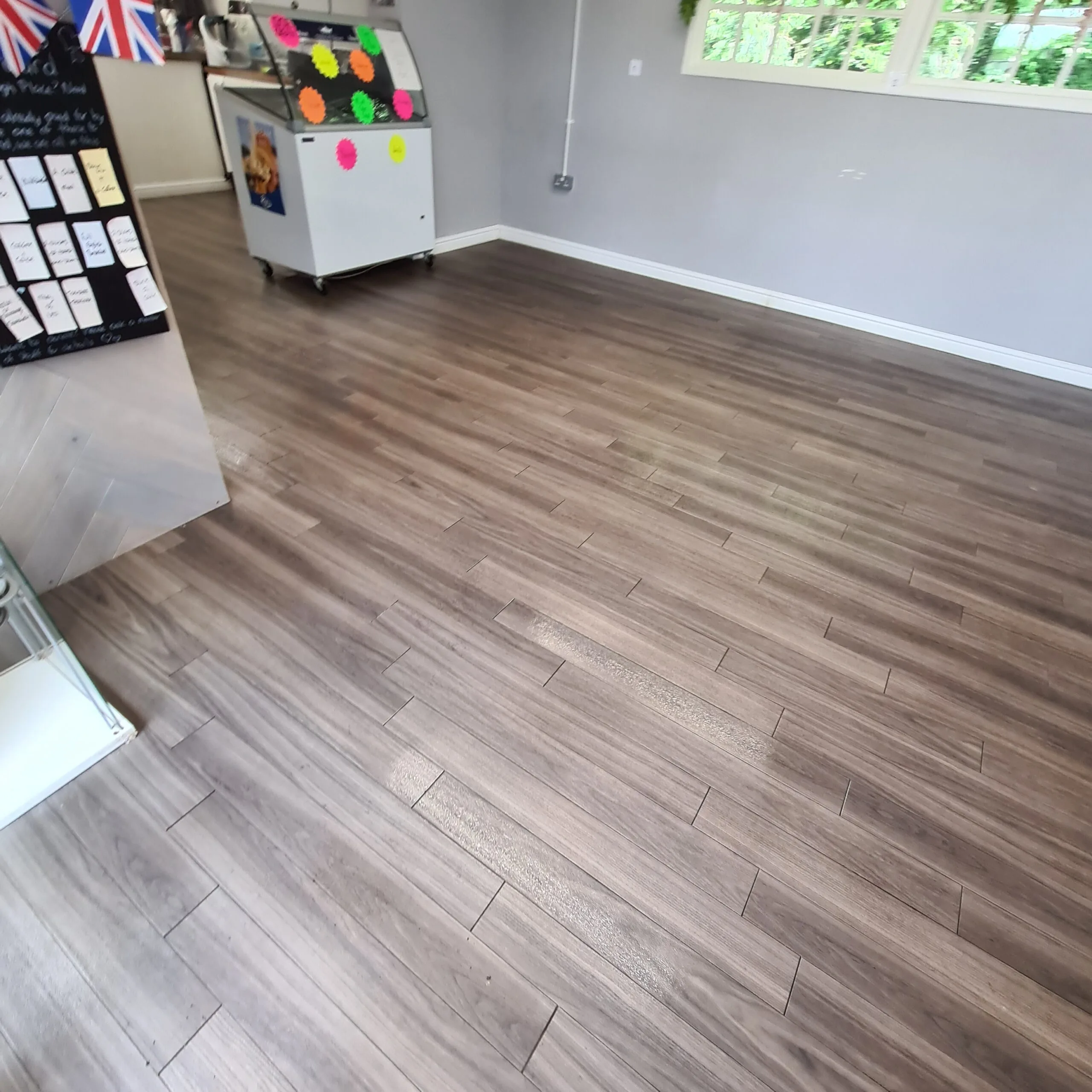 Grey wood-effect LVT floor after deep cleaning and resealing in a bright room