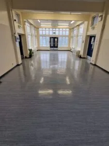 Grey vinyl safety flooring with a high-shine finish in a large entrance hall