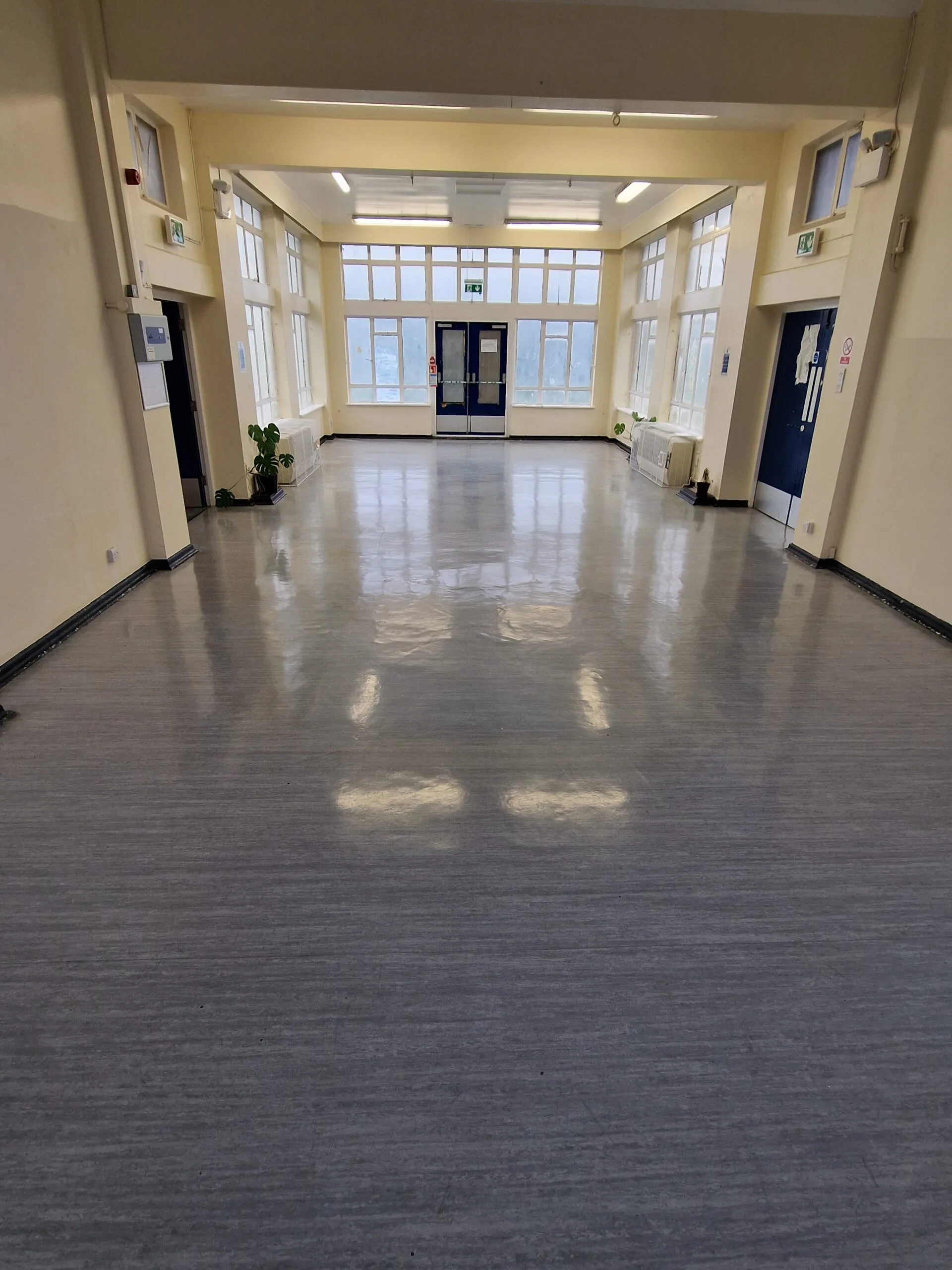 Grey vinyl safety flooring with a high-shine finish in a large entrance hall